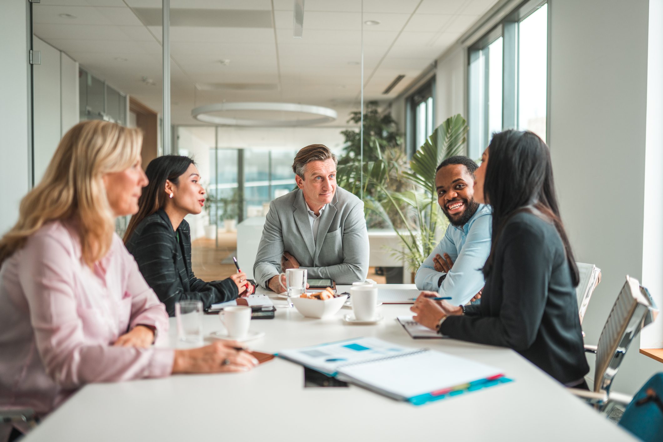 A diverse team collaborating happily in a modern office meeting.