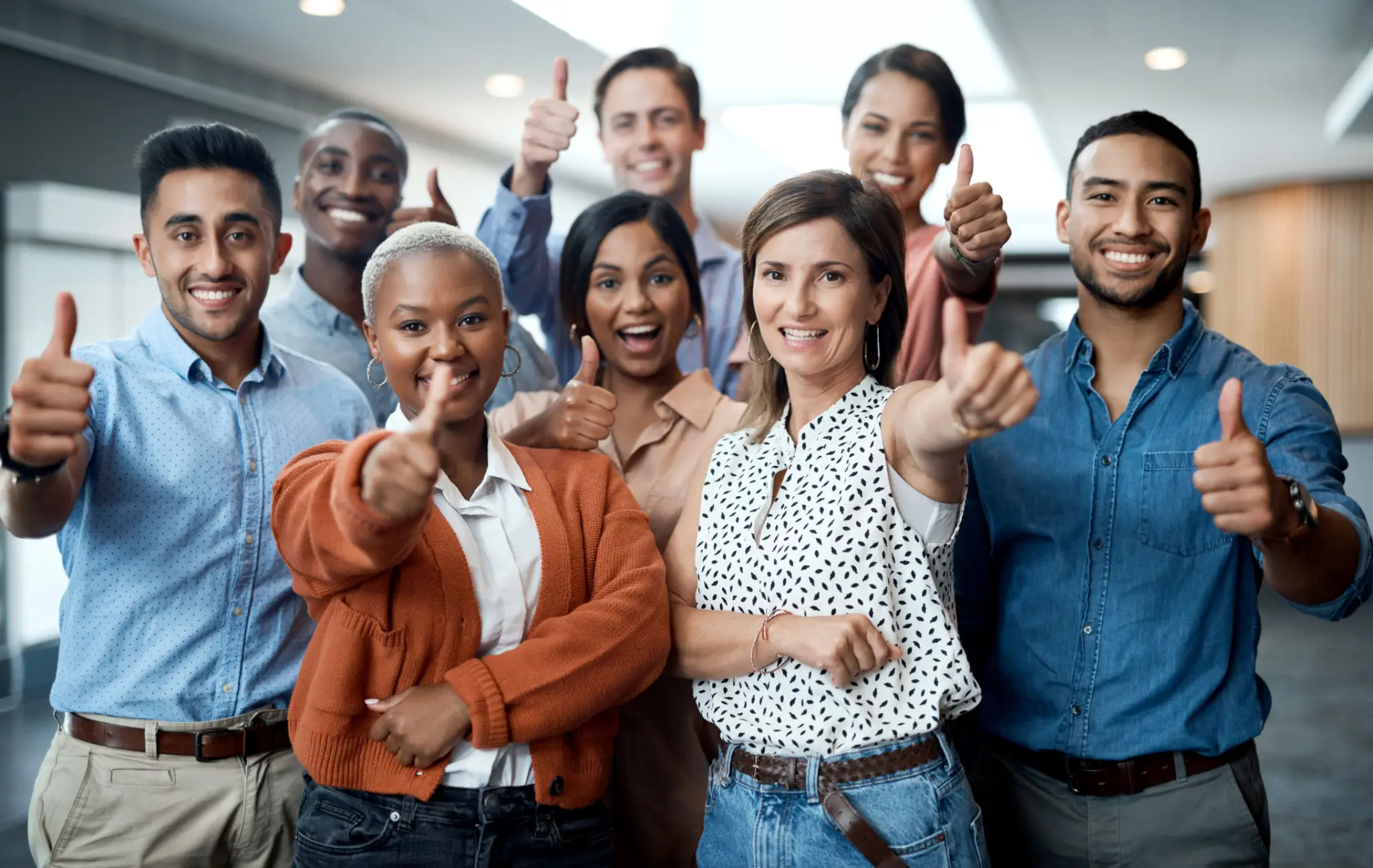 Diverse group of confident professionals posing together indoors.