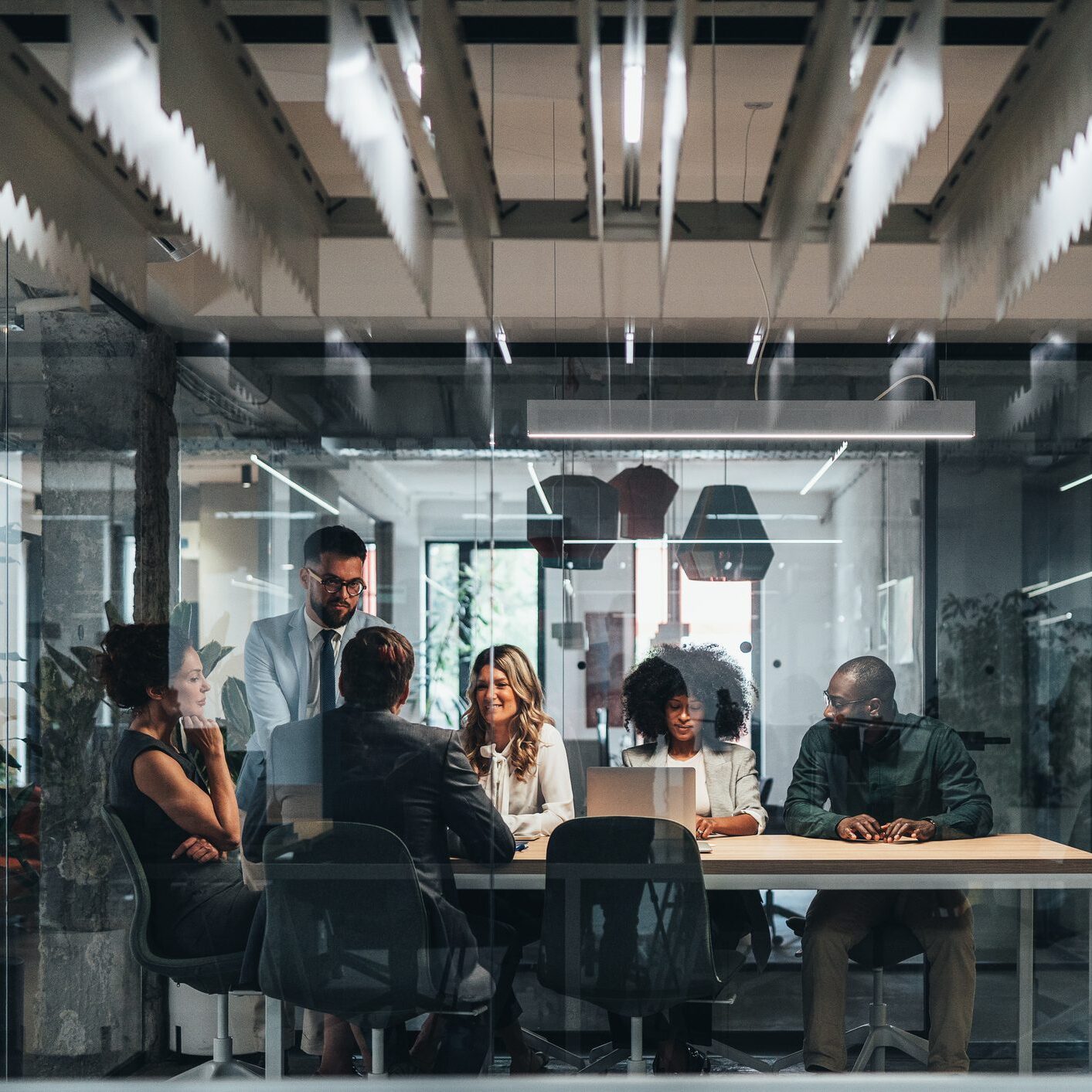 A team meeting in a modern glass-walled office room.